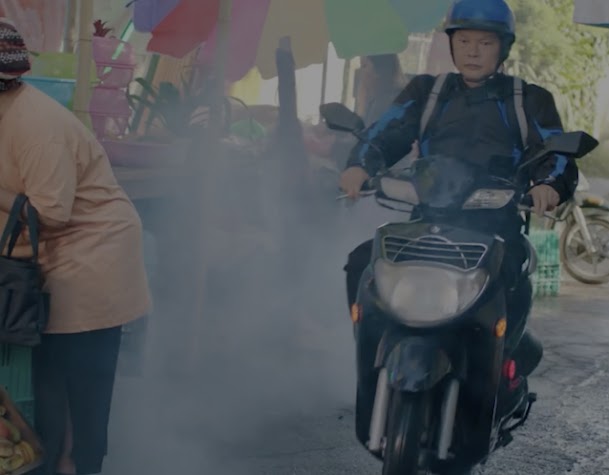 Livreur à moto traversant un marché